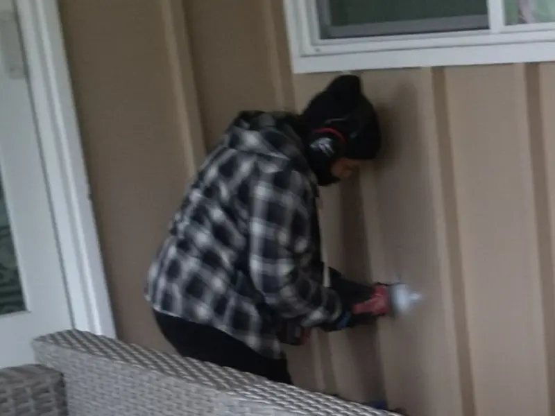 Professional electrician installing an exterior outlet in Peters
